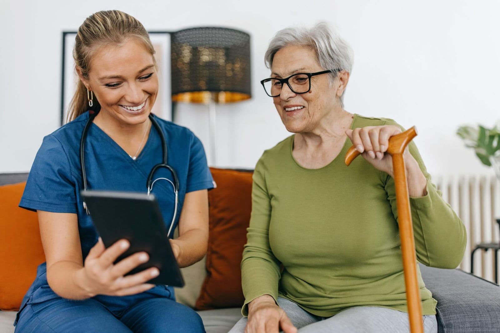 A nurse and an older patient reviewing information together at home.